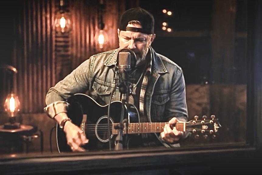 PATE playing guitar at the mic