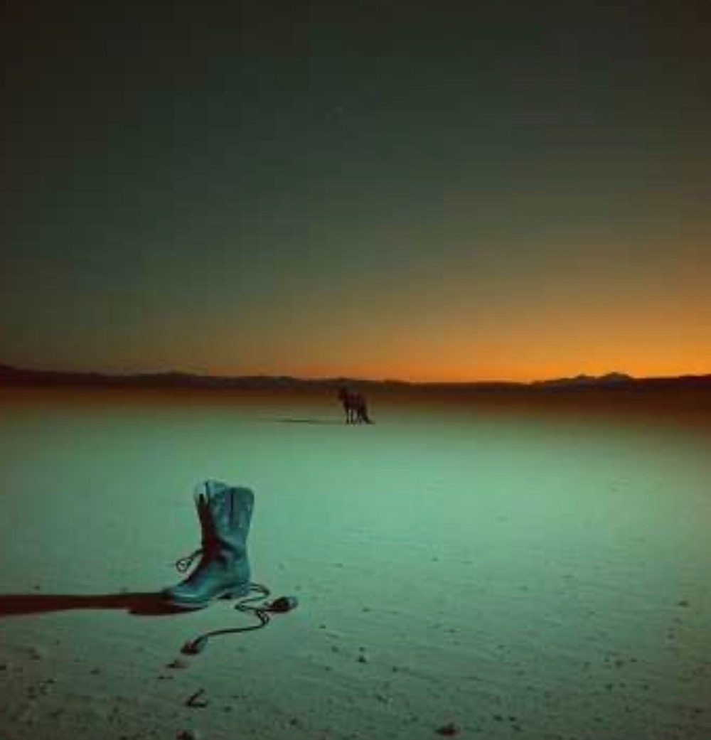 Cowboy boot at sunset horizon